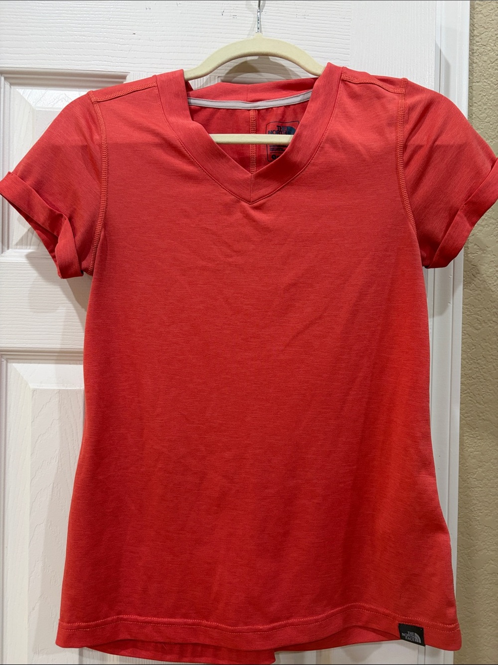 The North Face Women’s orange V-Neck Short Sleeve Tee